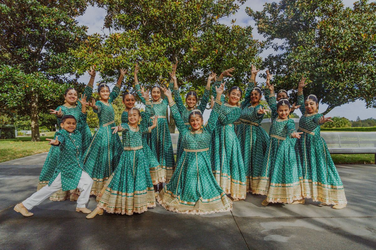 Dancers in teal at the 2023 parade through Disney Springs