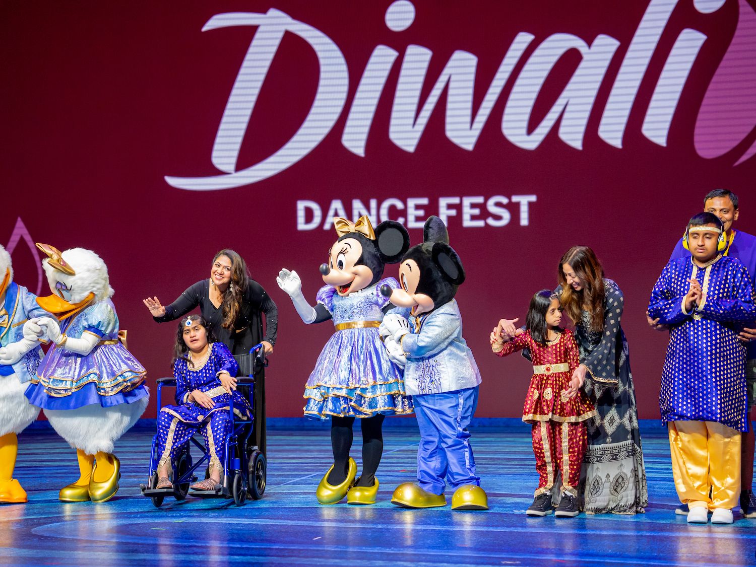 Mickey, Minnie, Donald and Daisy in festive outfits welcoming dancers on the Diwali Dance Fest stage