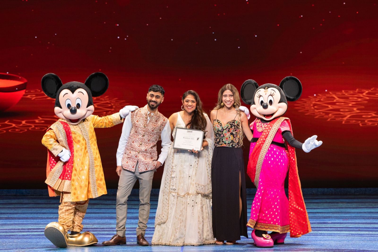 Mickey and Minnie celebrating with a studio on stage