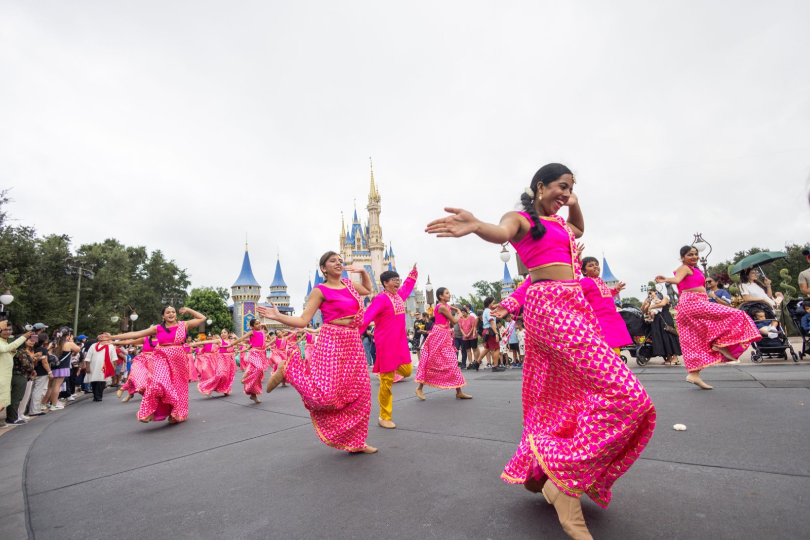 Dancers in pink twirling in front of Cinderella Castle